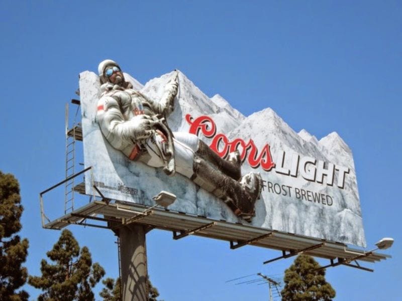 Biển quảng cáo 3D ngoài trời cho thương hiệu bia Coors Light, với dòng chữ đi kèm là "Frost Brewed" (ủ lạnh/ủ băng). - Biển Quảng Cáo OOH 3D: Ưu Điểm, Chi Phí & Top Mẫu Đẹp Biển quảng cáo 3D ngoài trời cho thương hiệu bia Coors Light, với dòng chữ đi kèm là "Frost Brewed" (ủ lạnh/ủ băng).