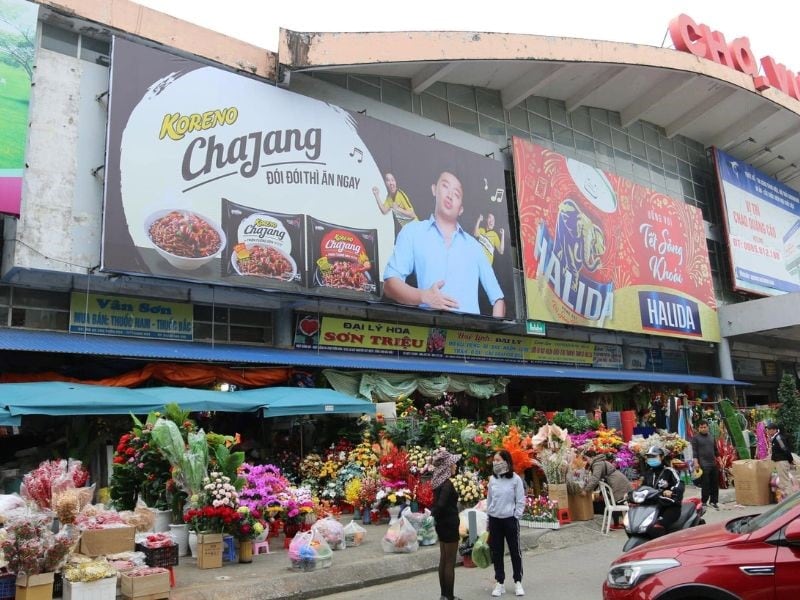Pano quảng cáo cỡ lớn trước cổng chợ nổi bật ngay khu vực kinh doanh sầm uất, thu hút sự chú ý của cả người đi bộ và phương tiện giao thông.